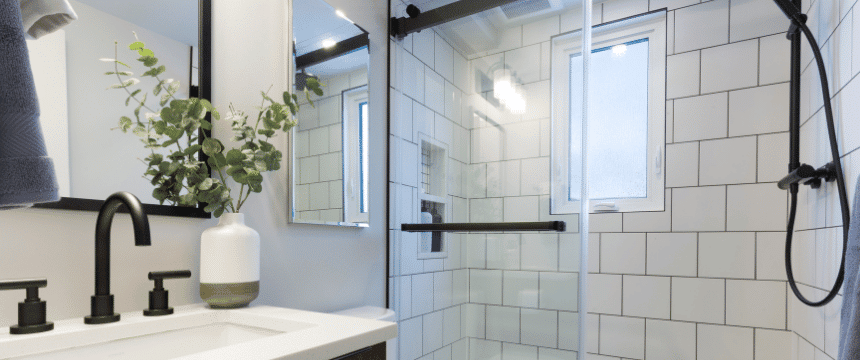 Walk-in shower with wide white subway tile and black accents