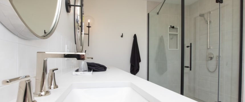 A stylishly crafted ensuite bathroom renovation with a large, walk-in, glass-enclosed shower that is custom tiled all part of a home renovation in Winnipeg for one of our many clients