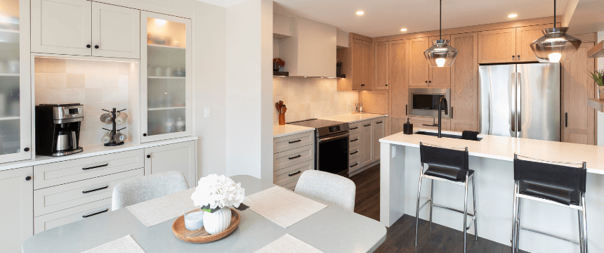 Forever home renovation specialist - A kitchen renovation with light wood and white cabinets, a large island with bar stools, and a dining area with a round table.